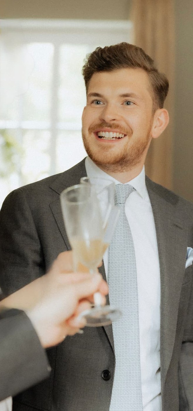 Luca Würz im Anzug beim Anstoßen mit Sektglas auf einer Hochzeit